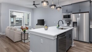 A modern kitchen with a central island, stainless steel appliances, and pendant lighting. - Southside Chatt Condo - 2BR, Pet Friendly! (Chattanooga)