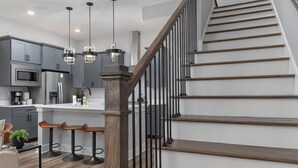 A modern kitchen with grey cabinets, stainless steel appliances, and pendant lighting. - Southside Chatt Condo - 2BR, Pet Friendly! (Chattanooga)
