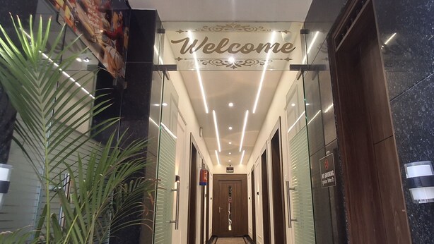Ein Hotel Eingang mit einem 'Welcome'-Schild, einem Rauchverbotsschild und einem Feuerlöscher.