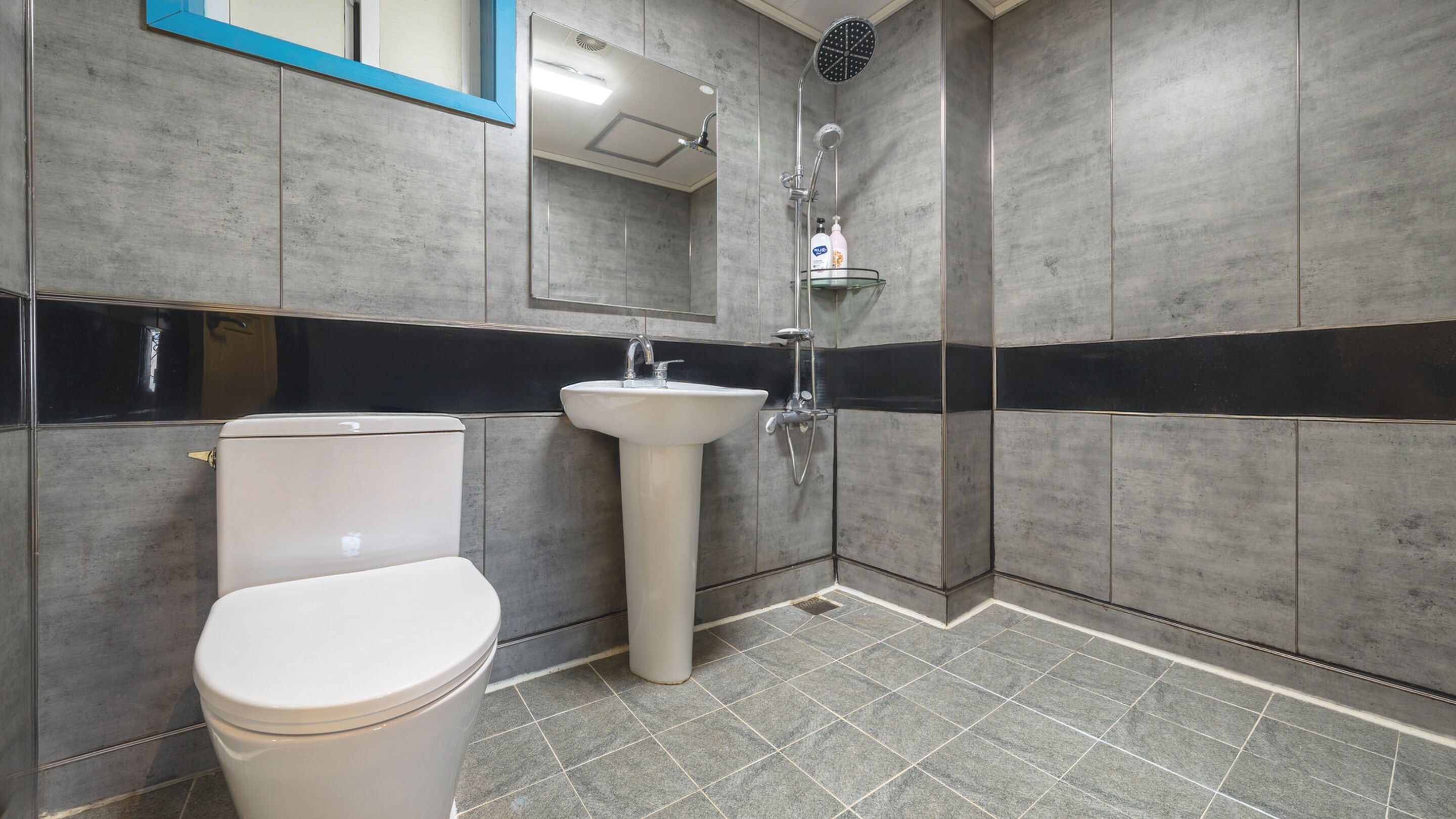 A bathroom with a toilet, sink, and shower.
