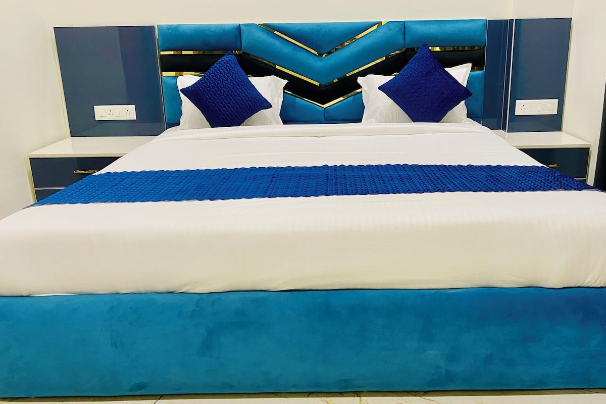 A bed with a blue headboard and footboard, white bedding, and two blue pillows.