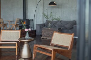 Una sala de estar acogedora con chimenea, muebles de madera y un jarrón con flores.