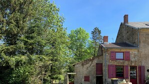A rustic stone house with red shutters, surrounded by trees and a grassy yard. - Family country house for 11 people (Bulson)