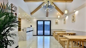 Un moderno vestíbulo de hotel con mostrador de recepción, mesas de madera y un gran ventanal con vistas.