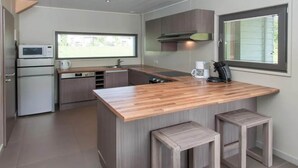 A modern kitchen with a wooden island, built-in appliances, and a window providing natural light. - Family Villa by the Lake (Boussu-lez-Walcourt)