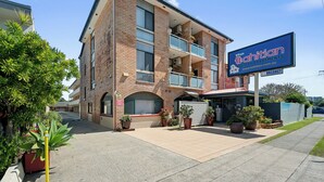 A two-story building with a sign advertising 'The Tahitian Holiday Apartments'.