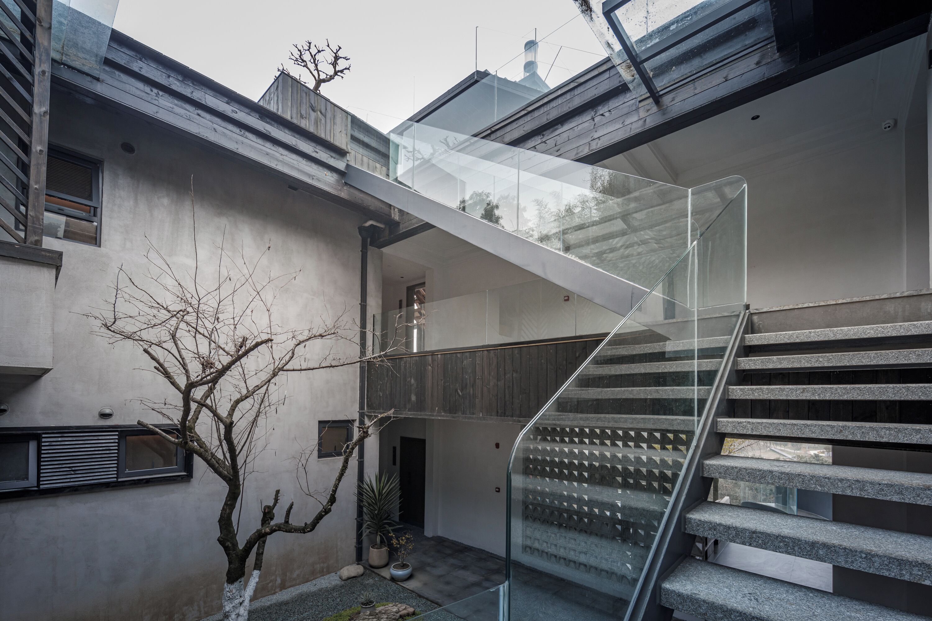 Un bâtiment moderne doté d’un escalier en verre reliant deux étages.
