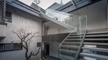 Un bâtiment moderne doté d’un escalier en verre reliant deux étages.