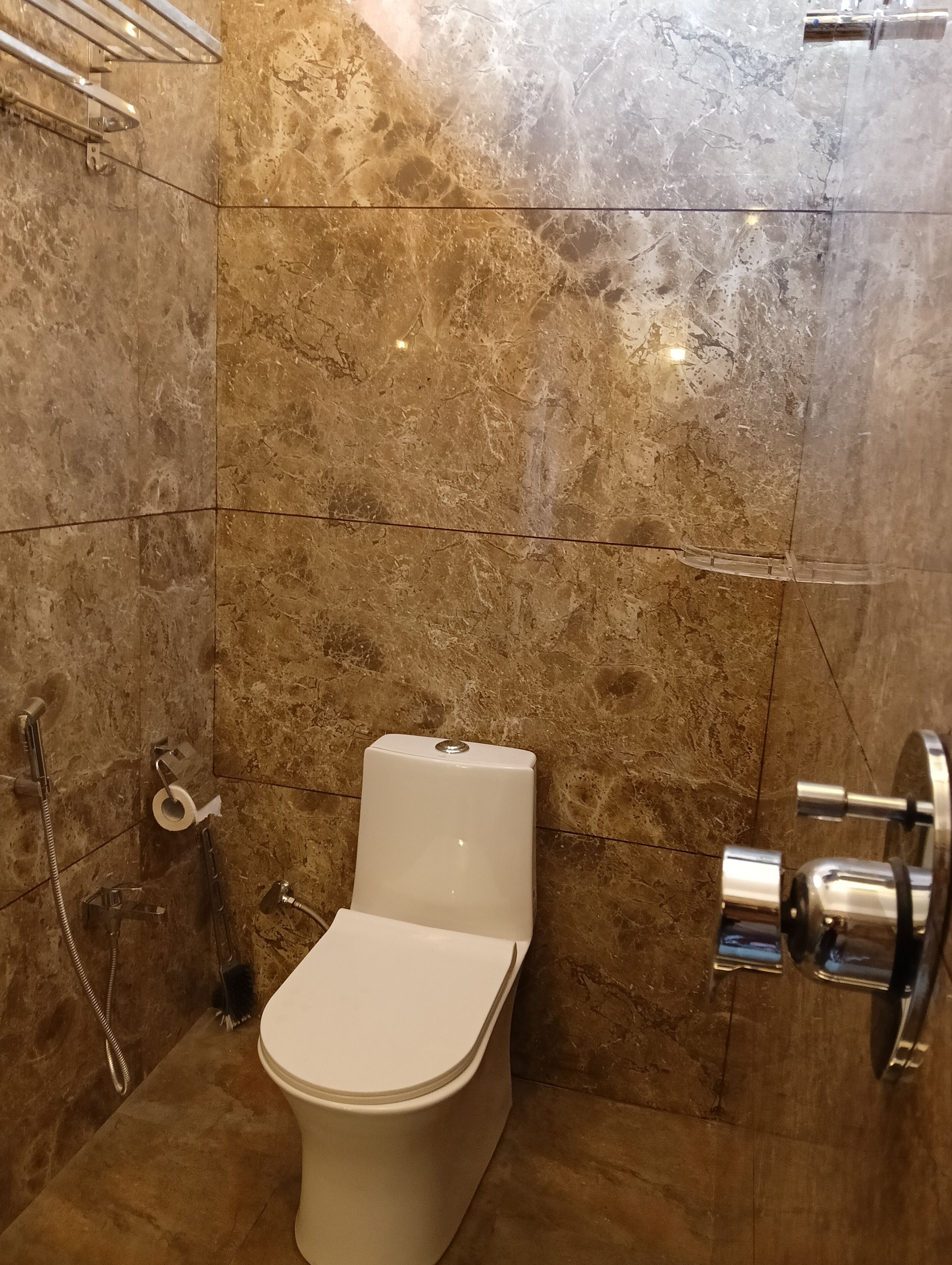 Un baño con inodoro, ducha y barra para toallas.
