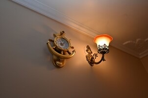 Un reloj de pared y una lámpara de pared con luz cálida.