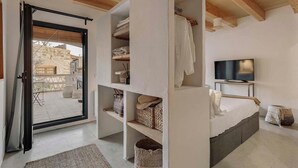 A bedroom with a bed, TV, and built-in shelving with storage baskets.