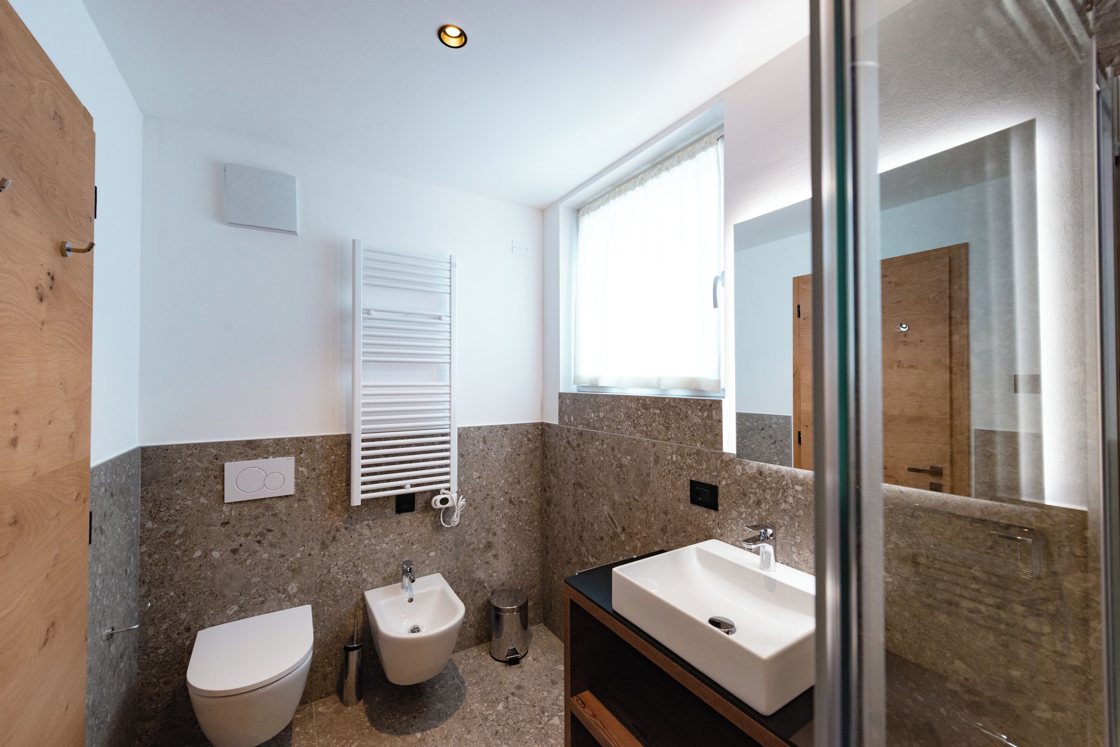 Un baño moderno con inodoro, bidé y lavamanos.