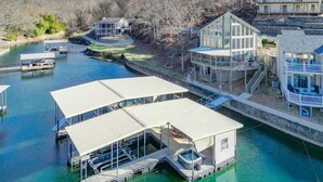 Una propiedad frente al agua con muelle, jacuzzi y zona de estar exterior techada.