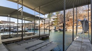 Zona de natación techada con un muelle y una escalera que da al agua.