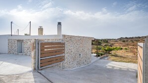 Un edificio de piedra con una puerta de madera, una chimenea y un cielo despejado.