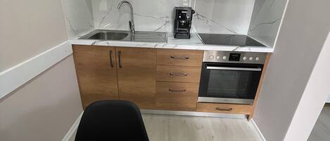 Geladeira, fogão, moedor de café, talheres/pratos/utensílios de cozinha