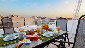A breakfast table with a view of the cityscape. - Athens Horizon Acropolis Views Apartment (Athens)