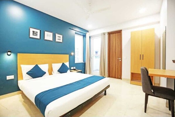 Una habitación de hotel con cama, escritorio y armario.