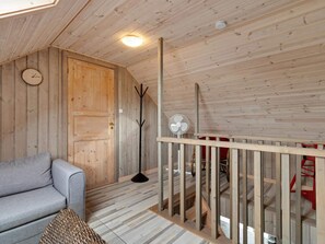 A wooden interior with a sofa, a coat rack, a fan, and a staircase. - 5 Star Holiday Home in Lokken (Lokken)