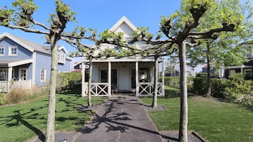 A residential property with a covered porch, a pathway leading to the entrance, and a lawn.