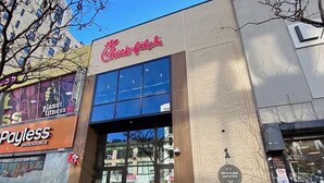 A Chick-fil-A restaurant with a large glass storefront and a Payless Shoesource store adjacent to it.