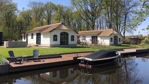 Une maison avec un quai et un bateau.