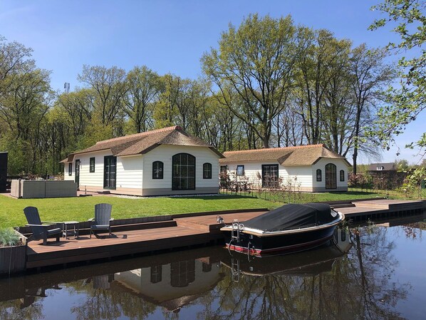 A house with a dock and a boat. - Farm Stay in Water-rich Friesland (Sint Nicolaasga)