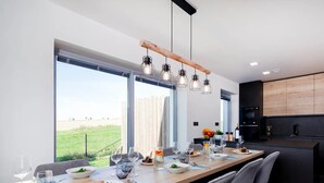 Un comedor moderno con una mesa larga, sillas y vistas al exterior.