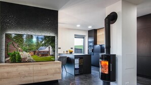 Una sala de estar moderna con un televisor grande, una chimenea y un comedor.