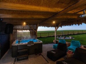 A hot tub with a view of a grassy field, wooden furniture, and a speaker. - Apartment in Moravia Near Ostrava Town (Frydlant nad Ostravici)