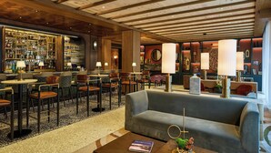 Eine Bar mit Holzbalkendecke, einer Couch und einem Couchtisch mit einem Buch.