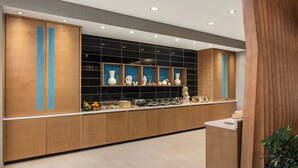 Une cuisine moderne avec des meubles en bois, un revêtement mural noir et divers objets décoratifs.