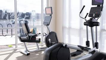 Une salle de sport intérieure équipée d’appareils de cardio-training, d’un tapis de course et d’un vélo elliptique.