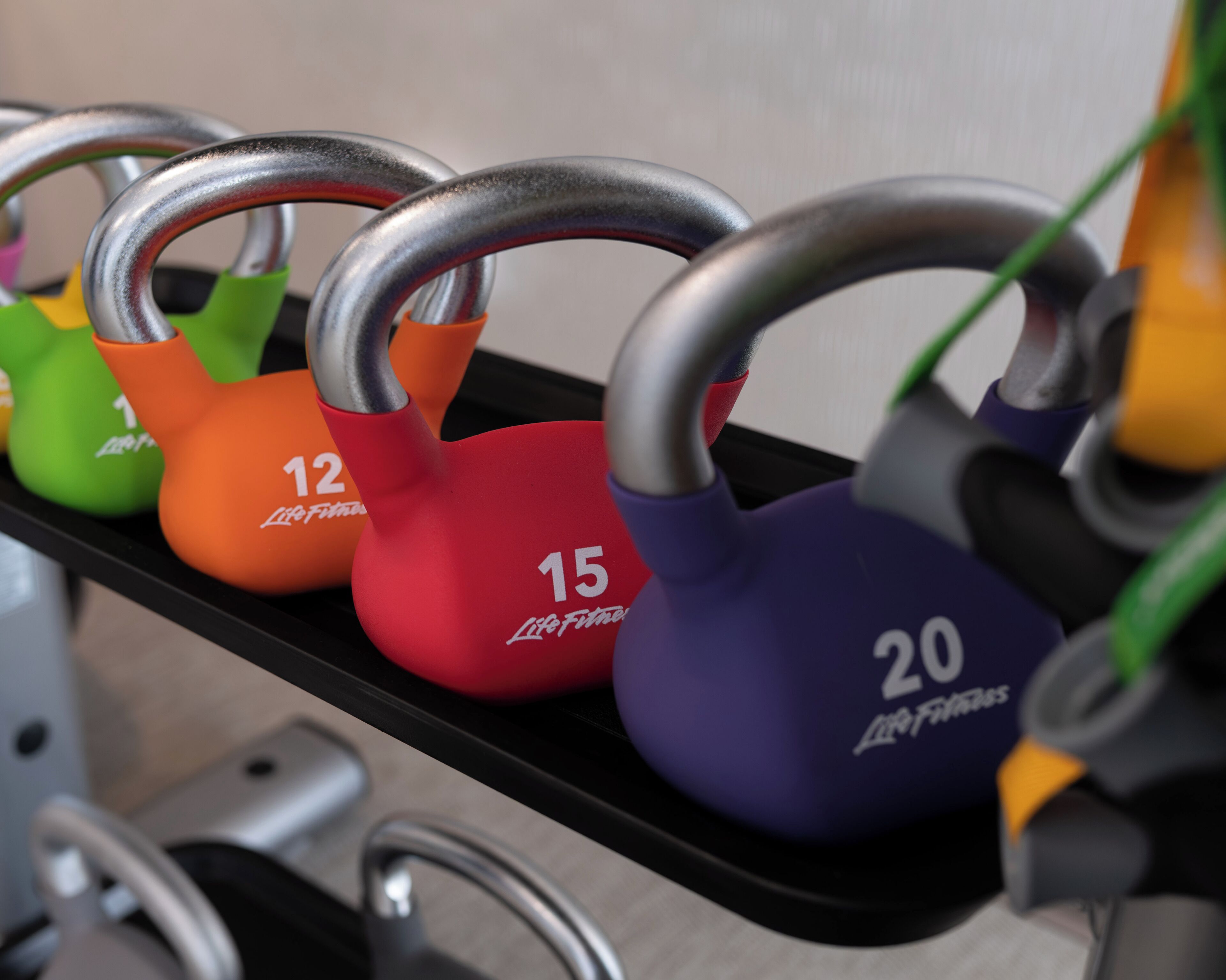 Una fila di kettlebell su un supporto, ognuna con un peso diverso indicato.