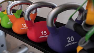 Una fila di kettlebell su un supporto, ognuna con un peso diverso indicato.