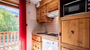 A kitchen with wooden cabinets, a built-in microwave, and a dishwasher.