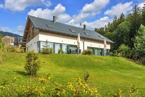 A modern house with a sloped roof, large windows, and a well-maintained lawn. - Villa Near Ski Resort Cerny Dul (Cerny Dul)