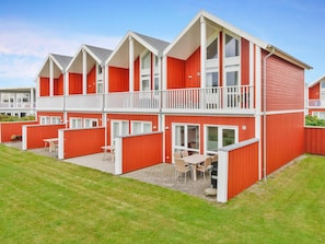 A red and white two-story building with balconies and a patio area.