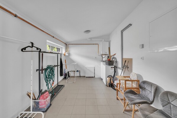 A clean, modern kitchen with white cabinets, a wooden countertop, and a hanging rack. - Villa in Cerny Dul Near Ski Resort (Cerny Dul)