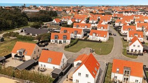 Zona residenziale con case caratterizzate da tetti in tegole rosse e pareti bianche, disposte a griglia con vista diretta sul mare.