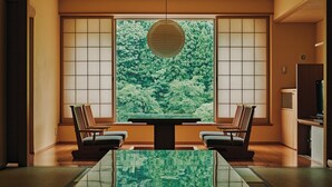 Une pièce de style japonais traditionnel, avec un sol recouvert de tatamis, une table basse et deux chaises.
