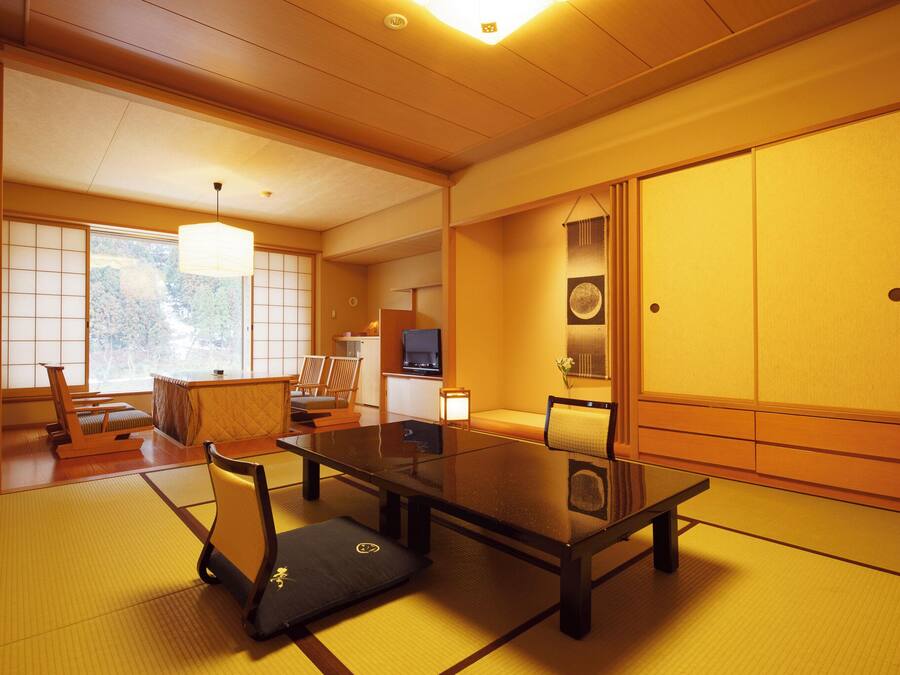 Een traditionele Japanse kamer met tatami vloerbedekking, een lage tafel en schuifdeuren.