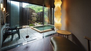 Une salle de bain moderne avec une douche à parois de verre, un banc en bois et une petite table.