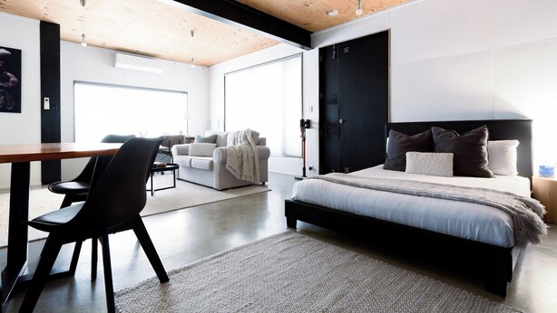 A modern bedroom with a large bed, a desk, and a chair. - Bright Studio in Launceston CBD (Launceston City)