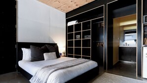A modern bedroom with a large bed, built-in storage, and a kitchenette in the adjacent space. - Bright Studio in Launceston CBD (Launceston City)
