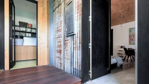 A modern interior with a wooden floor, a metal door, and a kitchen area visible through an open door. - Bright Studio in Launceston CBD (Launceston City)