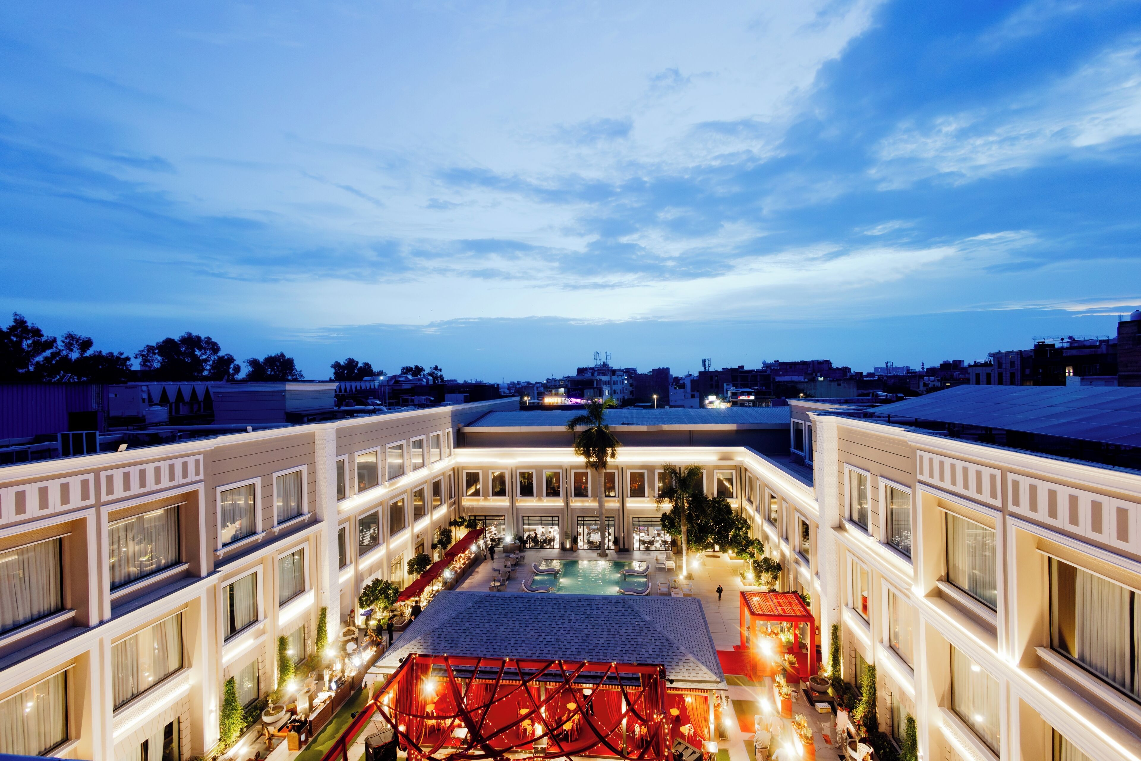 A hotel with a central courtyard, multiple floors, and a pool area.