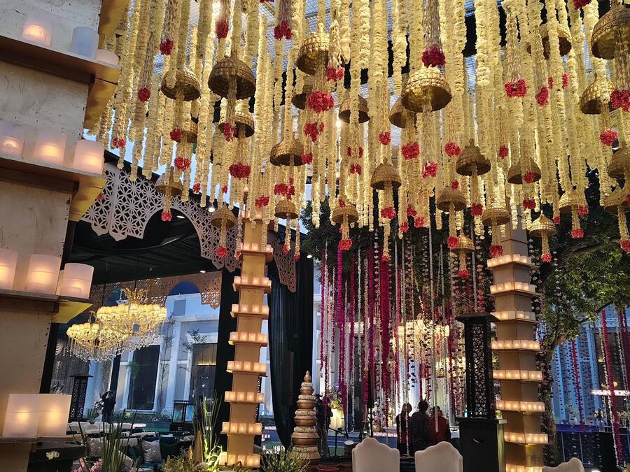An indoor setting with hanging floral decorations and chandeliers.