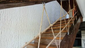 A wooden staircase with a rope safety net.