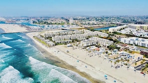 A coastal resort with beachfront villas, a sandy beach, and a marina. - Penthouse Ocean & Sunset Balcony Views -  G-323 (Oceanside)